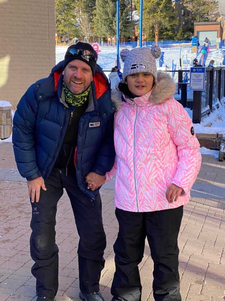 Father and daughter celebrate a successful ski day