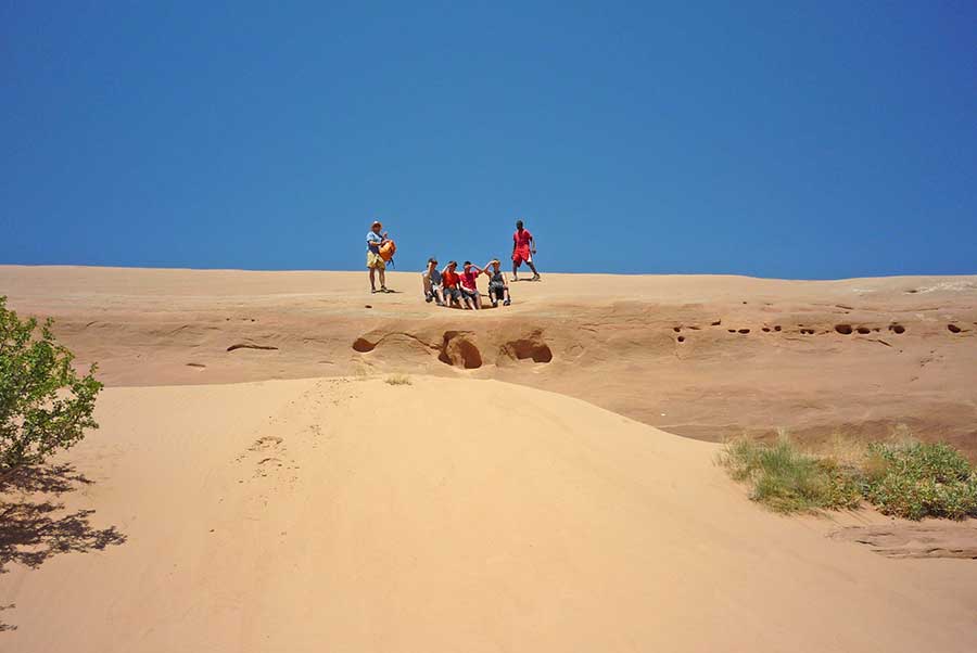 Boys on the cliff above a sand dune
