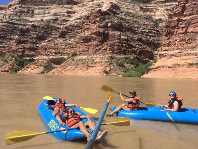 Girls relax in rafts on the river