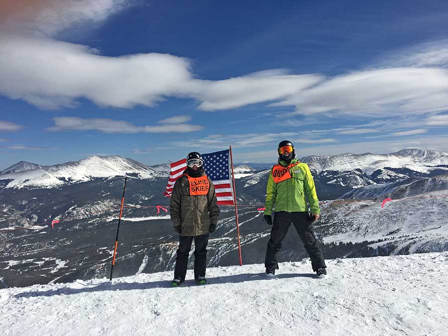 BOEC Intern Andy Roth poses at Breck Ski Resort with a blind skier